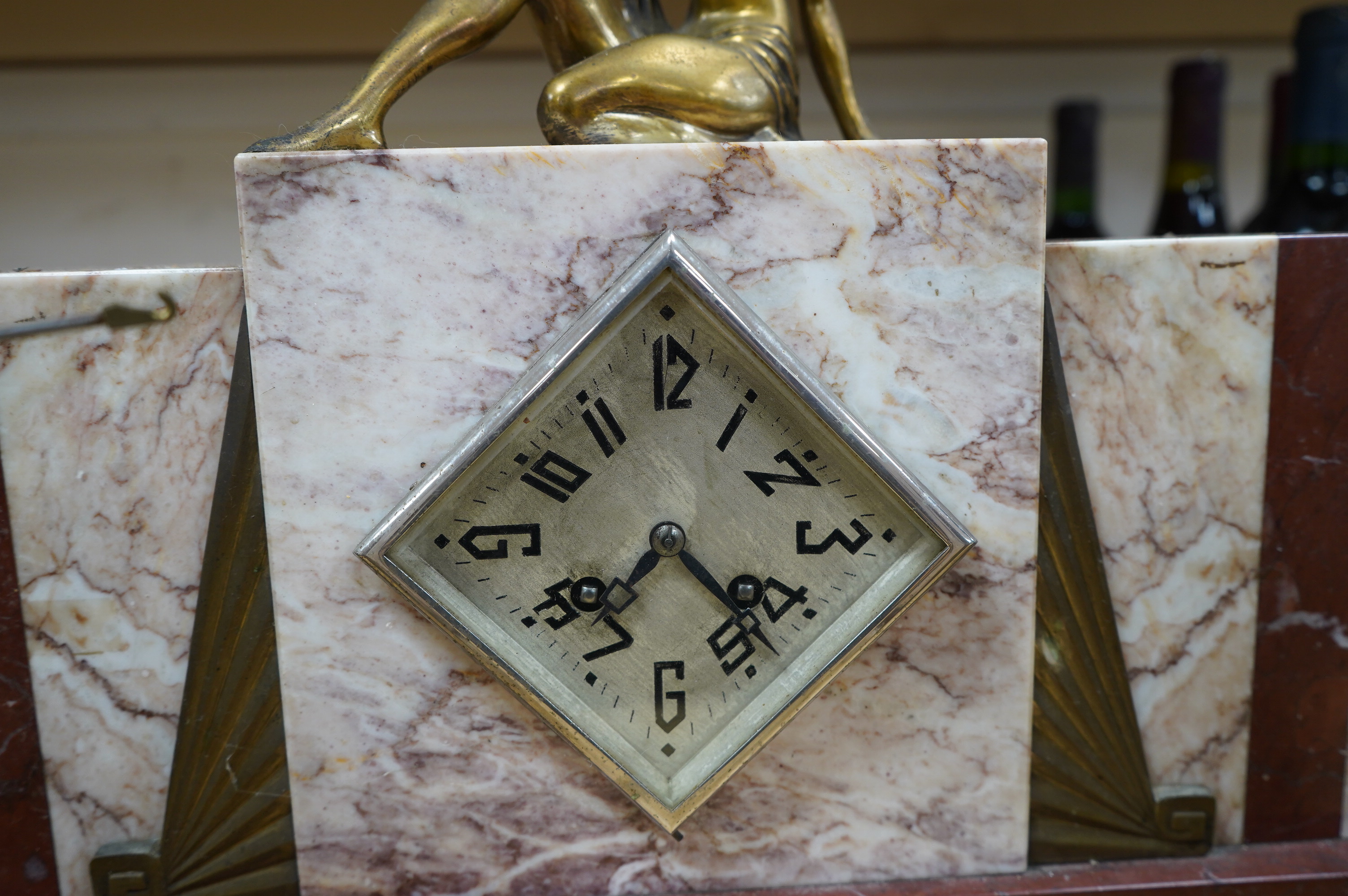 A French Art Deco brass mounted marble clock garniture with figural surmount, clock 38cm wide. Condition - good, unknown if clock working